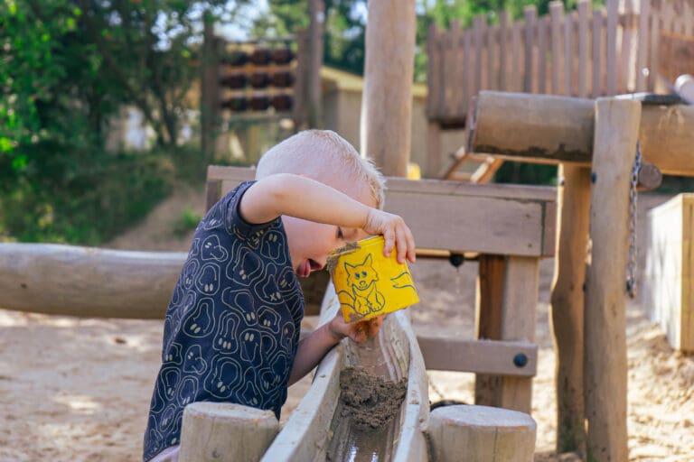 Kind giet water in watertoestel
