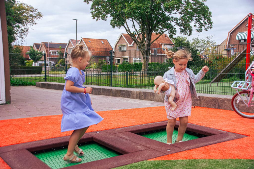 Kinderen springen op een trampoline bij een speeltuin