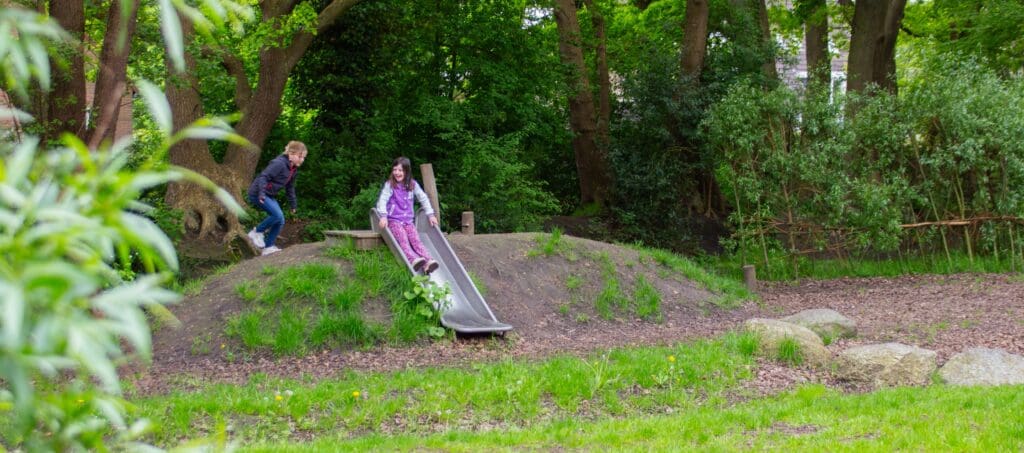 lekker glijden van het talud af op het groenblauwe schoolplein