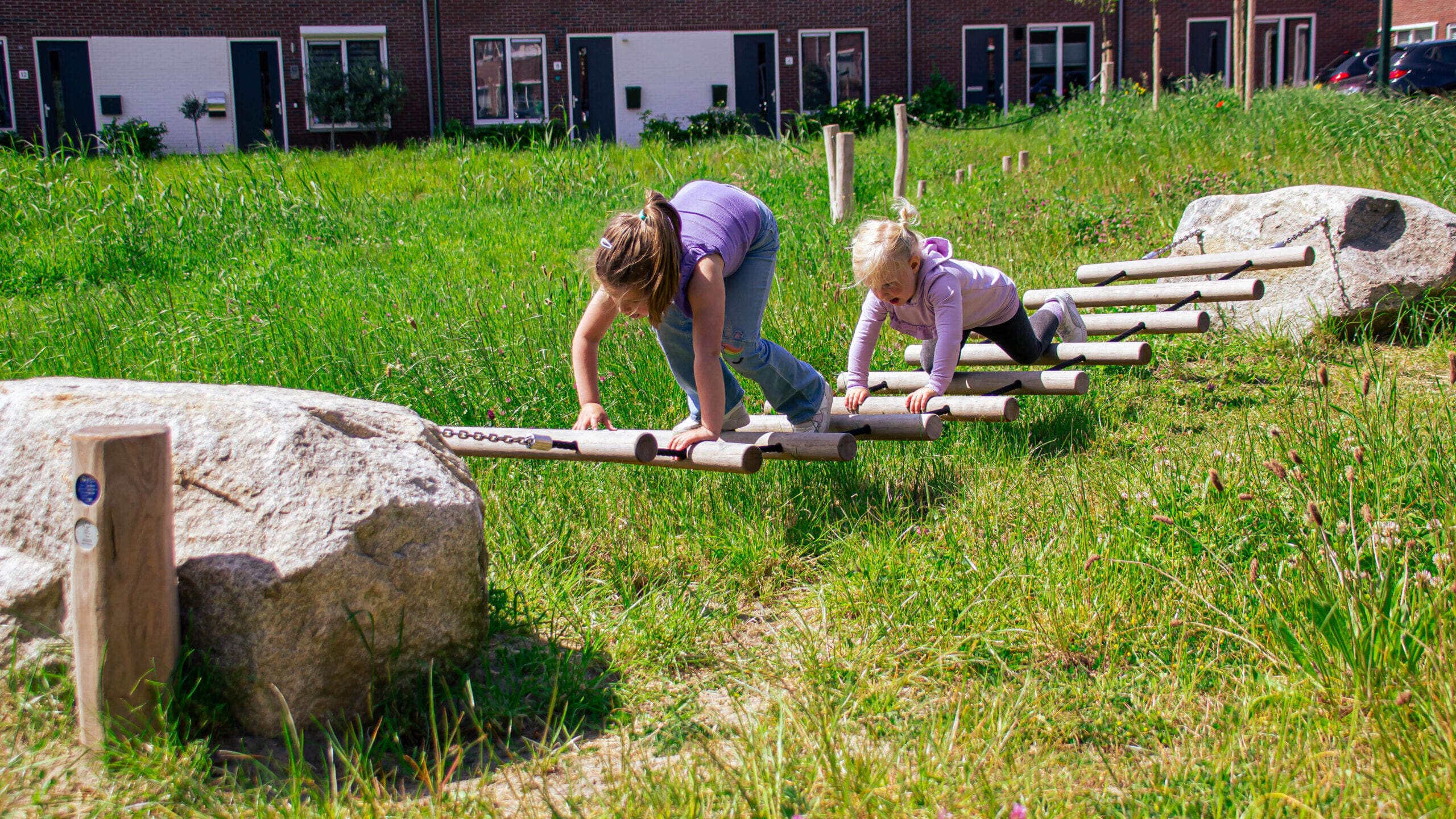 Kinderen houden hun evenwicht op een slackline van BOERplay op een speelplek in Raamsdonkveer
