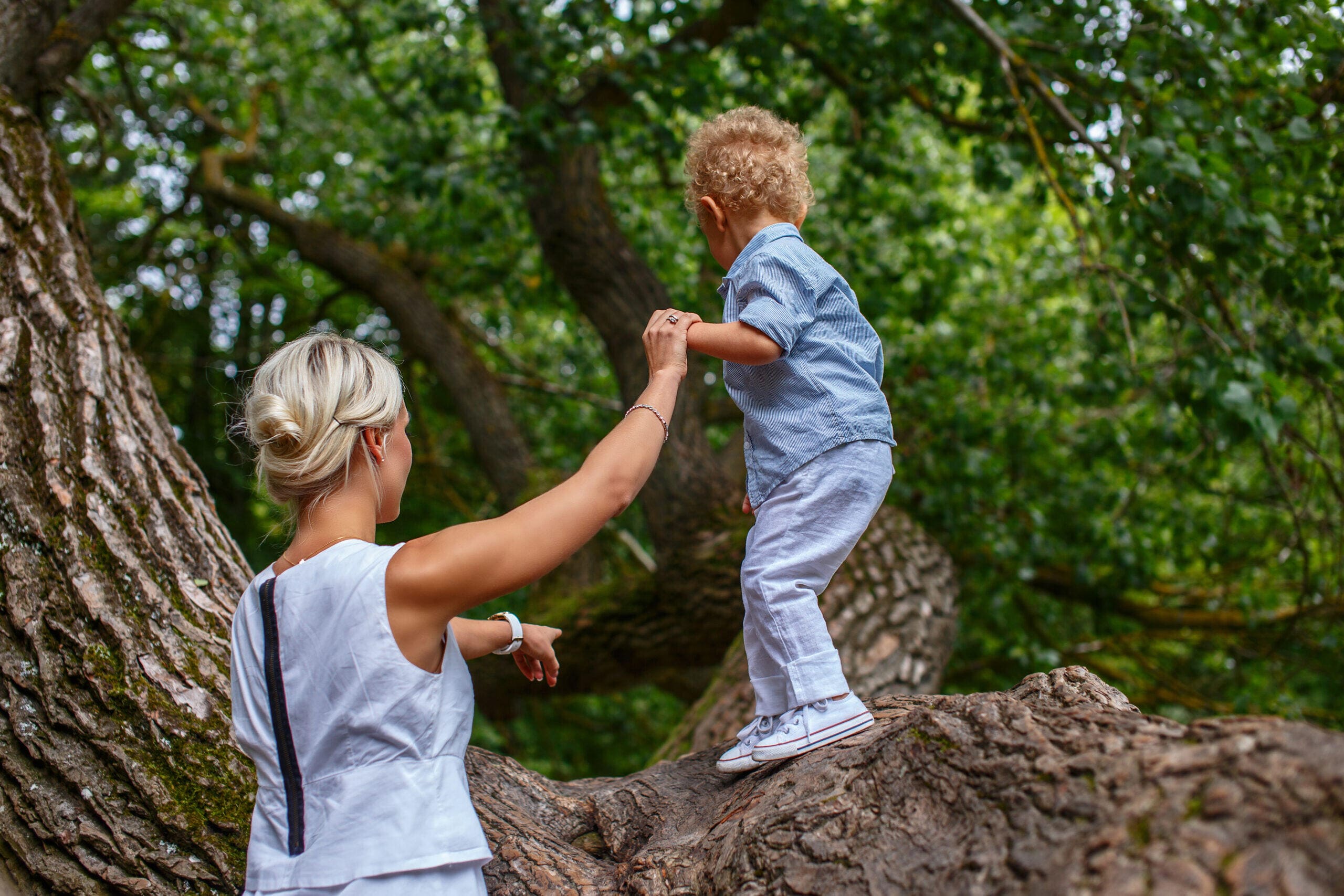 Moeder helpt haar kind bij klimmen en klauteren.